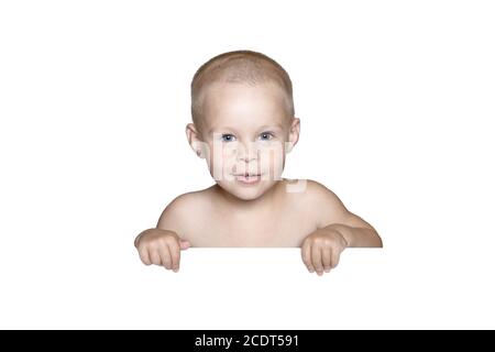 little child behind white board. Cute boy holding white board and looking in camera, isolated on white. Stock Photo