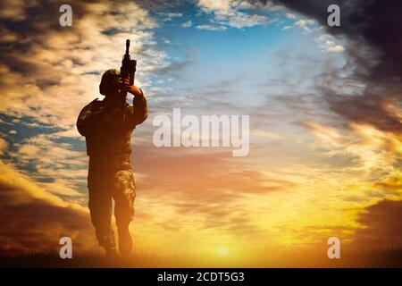 Soldier in combat shooting with his weapon, rifle. War, army concept Stock Photo