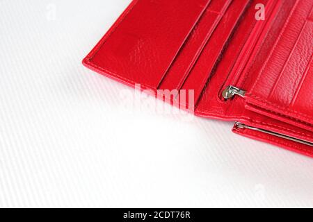 Red leather open purse lies on white surface. Women's accessories. Stock Photo