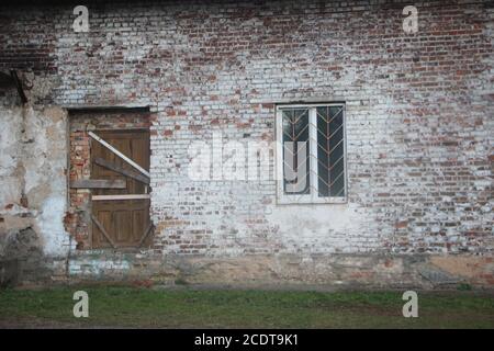 abandoned house with boarded up windows and decaying crumbling walls Stock Photo