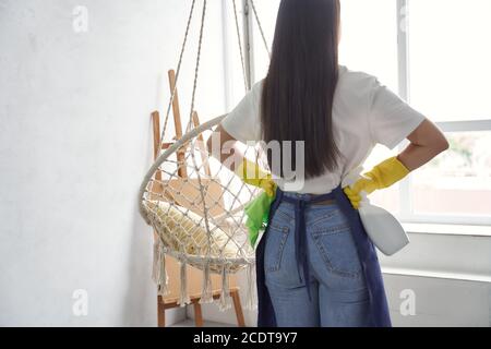 Man removing dirt from glass with squeegee. View of blue sky