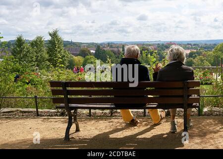 retired couple sitting on a bench in Quedlinburg and enjoy the view Stock Photo