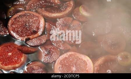 Mulled wine cooked on a fire outside. Close up. Vitamins in a winter drink. Street eatery. Hot mulled wine. Dense steam over cauldrons of hot wine Stock Photo