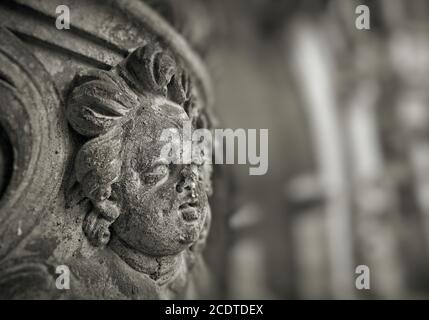 Weathered figure of an angel made of sandstone on the facade of a historic building in Dresden Stock Photo