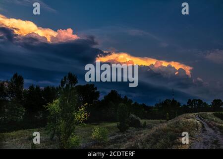 Dark cloud storm. Rain coming on the sky in the rural road view. Beautiful storm sky with dark cloud. Stock Photo