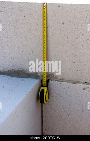 Roulette hanging on a aerated concrete wall, building a house out of aerated concrete. Stock Photo