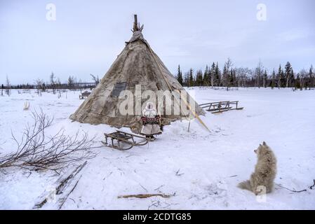 A Nenet young girl in front of her chum (traditional tent covered with reindeere hides), Yamalo-Nenets Autonomous Okrug, Russia Stock Photo