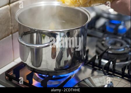 https://l450v.alamy.com/450v/2cdthhe/throw-pasta-into-the-pot-of-water-on-the-stove-fire-2cdthhe.jpg