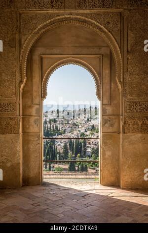 View of the Albayzin district of Granada, Spain, from an arched window in the Alhambra palace near sunset at Granada, Spain, Eur Stock Photo