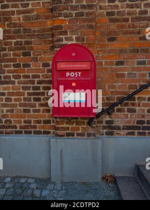 Red Vintage Mail Box hanging on a old terra cotta brick wall Stock Photo