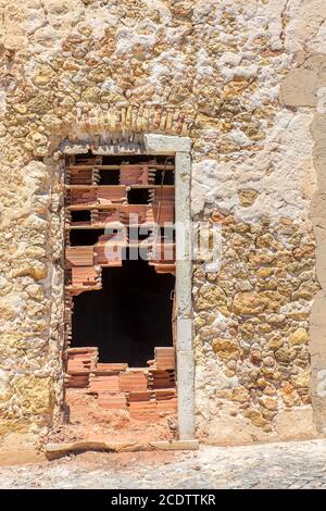 Stony house wall  with sealed door Stock Photo