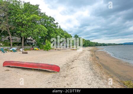 Red canoe on sandy riverfront Stock Photo