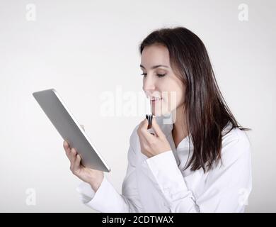 businesswoman with lipstick using digital tablet Stock Photo