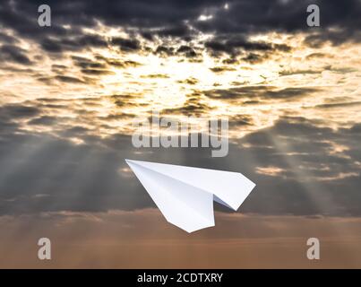 White paper airplane in a blue sky with clouds. The message symbol in the messenger Stock Photo