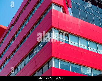 Red modern office building with open one windows Stock Photo