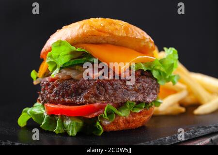 Beef burger with french fries, beef cutlet, cheese, vegetables Stock Photo