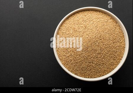 amaranth seeds in ceramic bowl isolated on dark background. top view Stock Photo