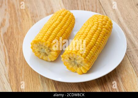 Freshly boiled corn on wooden background. Corn health benefits Stock Photo