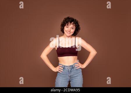 Happy young gorgeous Caucasian woman with short dark curly hair looking at you Stock Photo