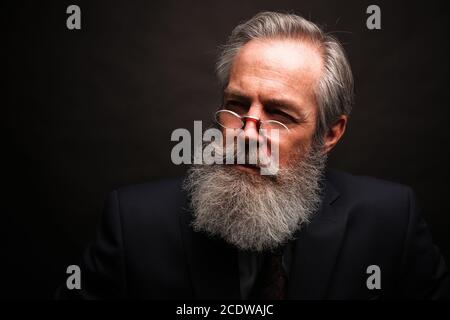 mature male model wearing suit with grey hairstyle and beard Stock Photo