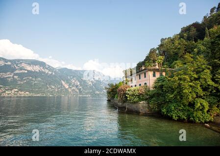 Bellagio. Lake Como. Italy - July 19, 2019: Stunning Landscape with Alps and Lake Como. Old Villa on Shore Among Trees. Stock Photo