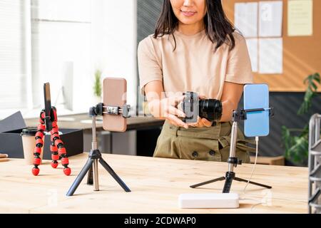 Asian female unpacking it and recording the process on smartphone camera Stock Photo