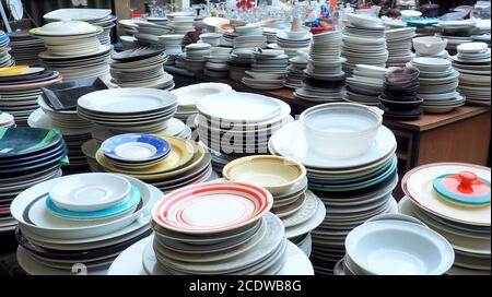 Cheap second hand white plates, stacked at Trash Palace, a junkyard for recycling household items Stock Photo