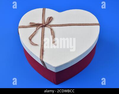 box for gifts in shape of heart on blue background Stock Photo
