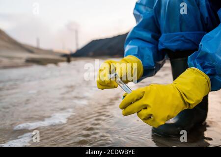 Contemporary ecologist in rubber gloves and boots and protective blue coveralls Stock Photo