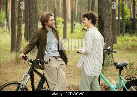 Smiling man looking at girlfriend and discussing pleasant moments of summer rest Stock Photo