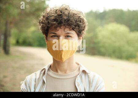 Contemporary young brunette woman in protective handmade mask