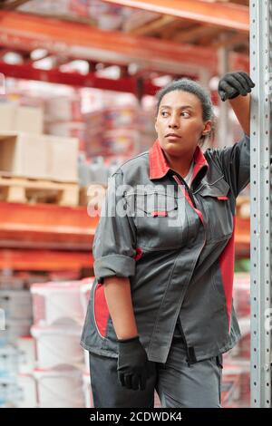 Middle aged mixed-race female worker of large contemporary warehouse Stock Photo