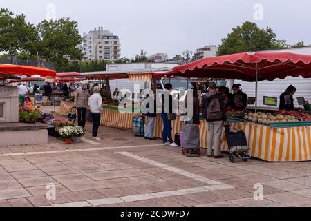 Angers, France - August 29 2020: people wearing face protective mask while shopping in the market place at France to prevent coronavirus, concept of wearing masks outdoor is mandatory, protection solutions Stock Photo