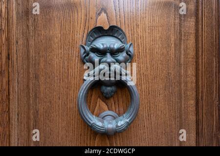 Metal knobs with decorative elements on a wooden door Stock Photo