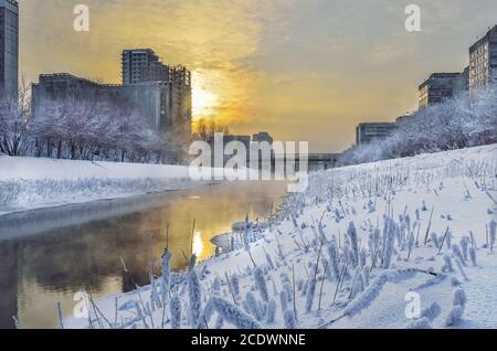 Golden sunset and fog over the river - urban winter landscape Stock Photo