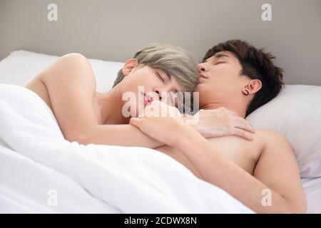 LGBT concept gay couples love Asian men cuddling in bed. Stock Photo