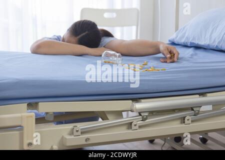 Female patients in the hospital overdose unconscious beside the bed. Stock Photo