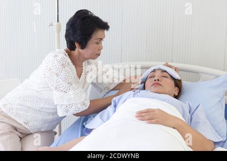 An Asian mother takes care of her sick daughter on a hospital bed Stock ...