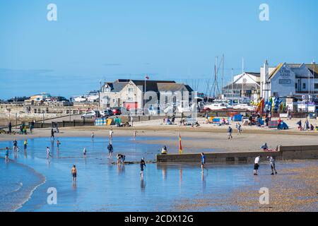 Lyme Regis, Dorset, UK. 30th Aug, 2020. UK Weather: Hardy holidaymakers and families set up on the beach on a bright, but chilly August bank holiday Sunday. Visitors are determined to make the best of the sunny, albeit it rather cold conditions on the last weekend of the school holidays. Credit: Celia McMahon/Alamy Live News Stock Photo