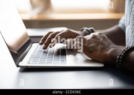 Close up African American male hands typing on laptop keyboard Stock Photo