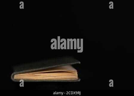 Single old book edge with Gray paper cover, isolated on black background Stock Photo