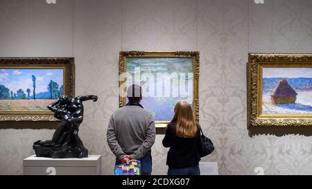 The Museum of Fine Arts, Boston, Massachusetts, United States of America - Vistiors looking at art works of Claude Monet, a French Impressionist. Stock Photo