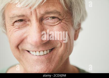 Close-up of happy senior man with white hair smiling at camera Stock Photo