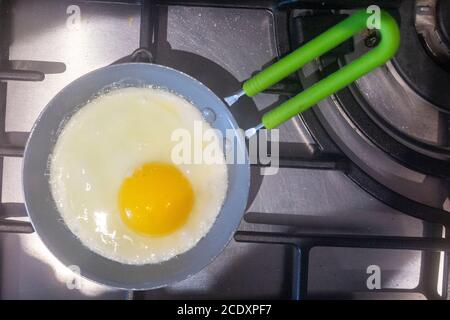 A single egg fries in a small frying pan Stock Photo
