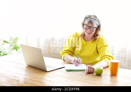 Mature woman using laptop at home Stock Photo