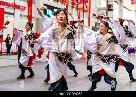 Japanese team of yosakoi dancers wearing long sleeved yukata dancing in shopping arcade during the Kyusyu Gassai festival at Kumamoto in Japan.