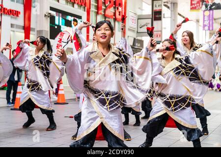 Japanese team of yosakoi dancers wearing long sleeved yukata dancing in shopping arcade during the Kyusyu Gassai festival at Kumamoto in Japan.