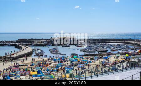 Lyme Regis, Dorset, UK. 30th Aug, 2020. UK Weather: Crowds of staycationers, holidaymakers and beachgoers flock to the packed beach at the seaside resort of Lyme Regis on Bank Holiday Sunday to make the best of what is set to be the last sunny day of the school holidays. Credit: Celia McMahon/Alamy Live News Stock Photo