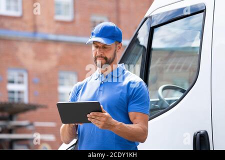 Delivery Man Near Truck Or Van Using Tablet Stock Photo