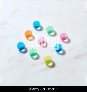 Diagonal pattern from hydrogel color balls on a grey marble table. Stock Photo
